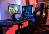 a desk with a computer and a gaming chair